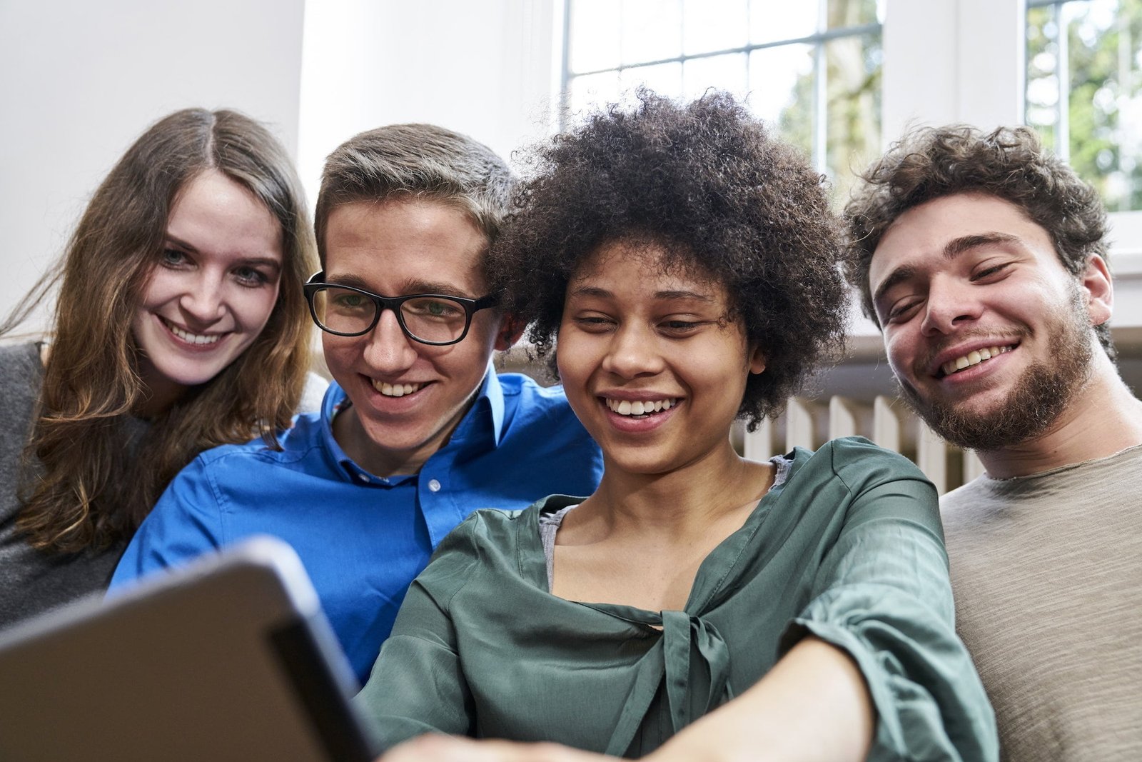 Smiling young people looking at tablet